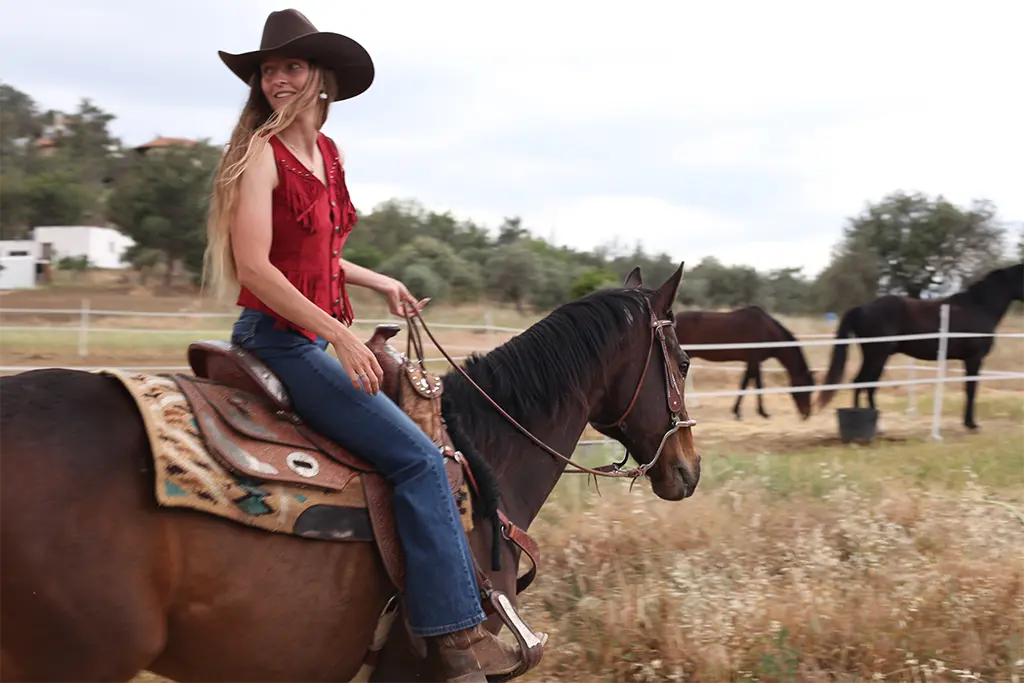 Woman riding a horse western riding style at Rock Rose Ranch